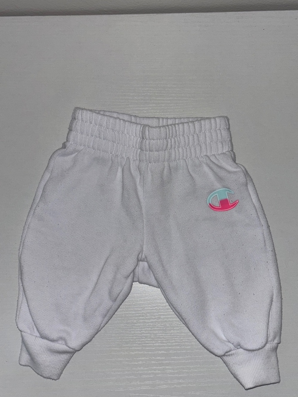 Champion: White Baby Sweatpants with Pink & Teal Logo Patch